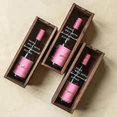 three bottles of wine in wooden boxes on a table