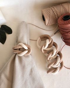 two spools of twine on top of a table next to some yarn