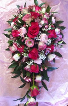 a bouquet of pink and white flowers sitting on top of a purple cloth covered floor