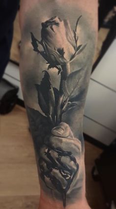 a black and white rose tattoo on the arm