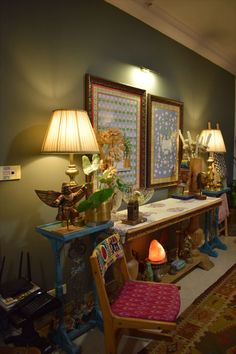 a room filled with furniture and lamps on top of it's sides in front of two framed pictures