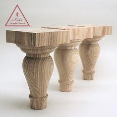 three wooden stools sitting next to each other on a white surface with a triangle sign above them