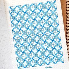 a notebook with a blue pattern on it and a pen in front of the page