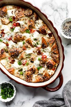 a casserole dish with meat and vegetables in it on a marble countertop