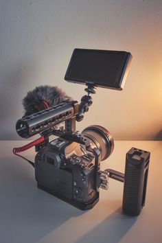 a camera with a microphone attached to it sitting on a table next to a light