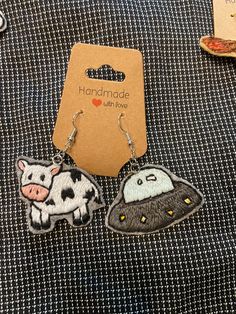 two earrings with pictures of animals on them