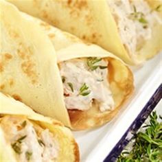 several tortillas on a white plate with green garnish