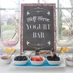 a sign that says yogurt bar in front of bowls of fruit and dips