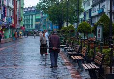 two people walking down the street on a rainy day