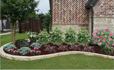 a flower bed in front of a brick building