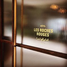 a hotel sign on the side of a glass door that says les roches rouges