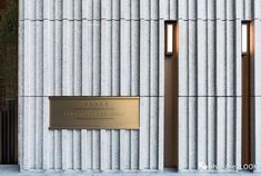 the entrance to an office building with two metal doors and a sign on the side