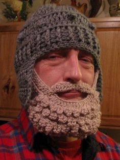 a man wearing a crocheted hat with a beard and mustache is looking at the camera