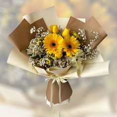 a bouquet of sunflowers wrapped in brown paper