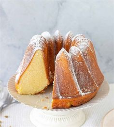 a bundt cake sitting on top of a white plate next to a slice cut from it