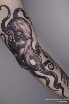 an octopus tattoo on the arm with black ink and white ink, is shown in this image