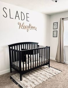 a baby's room with a black crib and white rug on the floor