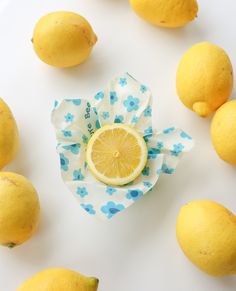 the lemons are laying on the table next to the cloth with it's cut in half