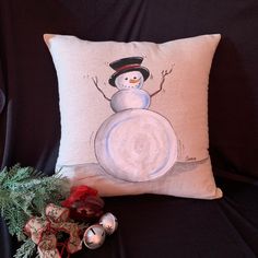 a snowman pillow sitting on top of a black couch