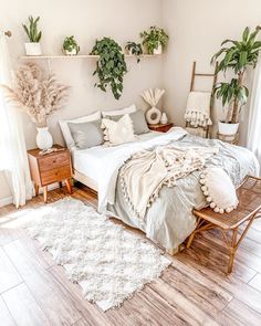 a bed sitting in a bedroom next to two potted plants