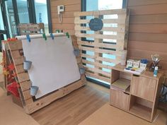 a room with wooden pallets and a white board on the wall next to a window