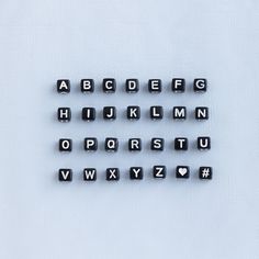 several black and white letters are arranged in the shape of small magnets on a white surface