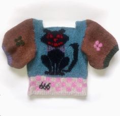 a knitted sweater with a black cat on the front and pink, purple, and blue sleeves