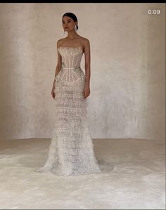 a woman in a wedding dress standing on a white floor