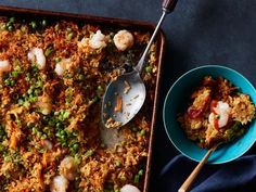 a blue bowl filled with rice and shrimp next to a plate full of scallops