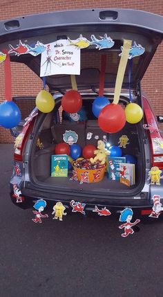 the trunk of a car decorated with balloons, books and other items for children's birthday