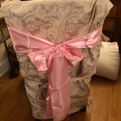 the back of a chair with pink ribbon on it