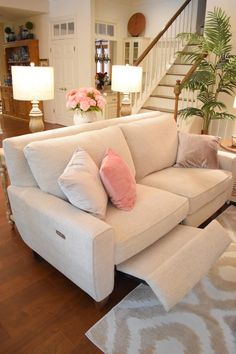 a living room filled with furniture and a stair case in front of the couches