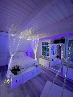 a white bed sitting in a bedroom next to a window with purple lights on it