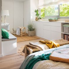 a bed room with a neatly made bed next to a window and a shelf full of books