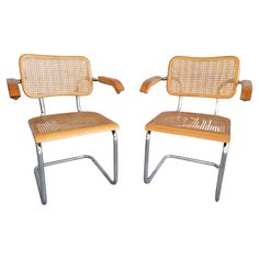 two chairs made out of wood and metal, one is bent to the side while the other has no arms