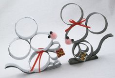 two metal mice with bows and bells on their backs, one holding a present in its paws