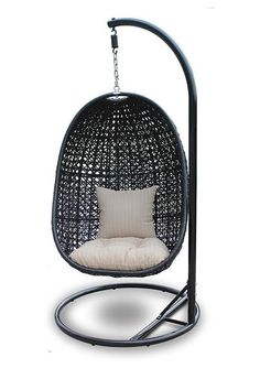 a black swing chair with a white pillow on it