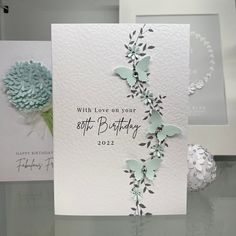 two greeting cards, one with flowers and the other with butterflies on it are sitting on a table