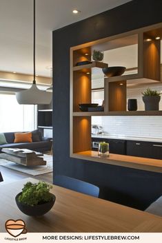 a modern kitchen and living room with open shelving units on the wall, along with potted plants