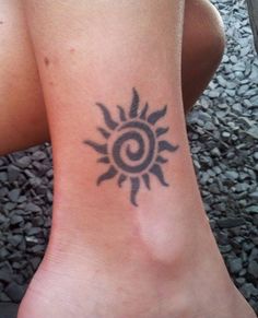 a woman's foot with a small tattoo on the side of her leg and an image of a sun