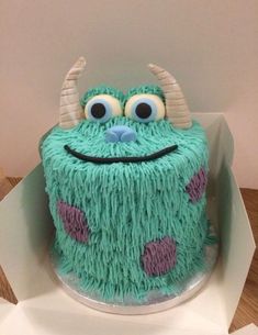 there is a cake that looks like a monster with big eyes and horns on it