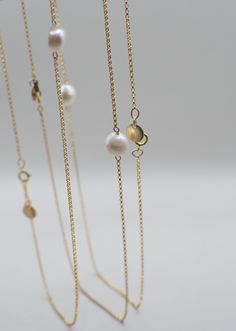 Named after a spin on the lovely Marigold flower, this pearl necklace symbolizes divinity as well as the beauty of patience on your journey to growth/alignment. She adds a simple-yet-striking touch of elegance and grace, and is very versatile for styling! Made with high-quality 14K Gold Filled materials, the Merrigold necklace is both water/tarnish-resistant, so you can swim all day and night under the sun and moon. NECKLACE DETAILS: 14K Gold-Filled Chain Freshwater Pearl Unique 14K Gold-Filled GEO Tag MEASUREMENTS: 16.5" Necklace Note: Many GEOLOVERS pieces are uniquely handmade. Each piece may vary slightly as a result, including the shapes of natural pearls. Elegant Long Charm Necklaces For Everyday, Delicate Akoya Pearl Jewelry With Delicate Chain, Feminine Gold Jewelry With Pearl Charm, Graceful Yellow Gold Jewelry With Pearl Drop, Everyday Gold Feminine Pearl Necklace, Graceful Yellow Gold Pearl Drop Jewelry, Gold Pearl Necklace For Everyday Feminine Style, Gold Long Single Strand Necklace, Feminine Everyday Gold Pearl Necklace