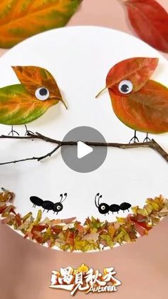 the paper plate is decorated with leaves and birds on it's face, as if they were looking at each other