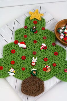 a crocheted christmas tree rug next to a bowl of candy