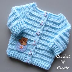 a blue knitted sweater with a teddy bear on it