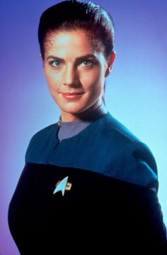 a woman with short hair wearing a star trek uniform