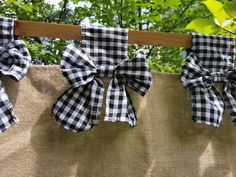 black and white checkered bows hanging on burlocked fabric with trees in the background