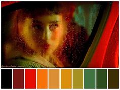 a girl looking out the window with rain drops on her face and red curtains behind her