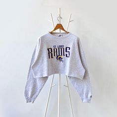 90 St. Louis Rams NFL cropped sweatshirt/ L * PLEASE READ BEFORE PURCHASE * PLEASE consider the PHOTOS before making the decision * The images may DIFFER in appearance from the actual product because we took pictures under daylight.  * PLEASE send your PHONE NUMBER after your purchase for the shipping company to contact you X No returns X No refund Condition : 9/10 More details : look at the pictures  Brand : Lee Size : L Pit to pit/ Chests : 27/54 inches  Length : 18 inches  Material : cotton p Cropped Tops With Ribbed Cuffs For Streetwear, Fall Streetwear Crop Top With Crew Neck, Fall Cropped Sweatshirt For Streetwear, Cropped Sweatshirt For Fall Streetwear, Winter Streetwear Crew Neck Crop Top, Winter Crew Neck Crop Top For Streetwear, Winter Streetwear Crop Top With Crew Neck, Cropped Cotton Sweatshirt With Graphic Print, Graphic Print Cropped Cotton Sweatshirt