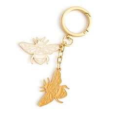 a keychain with a bee on it and a small insect on the back